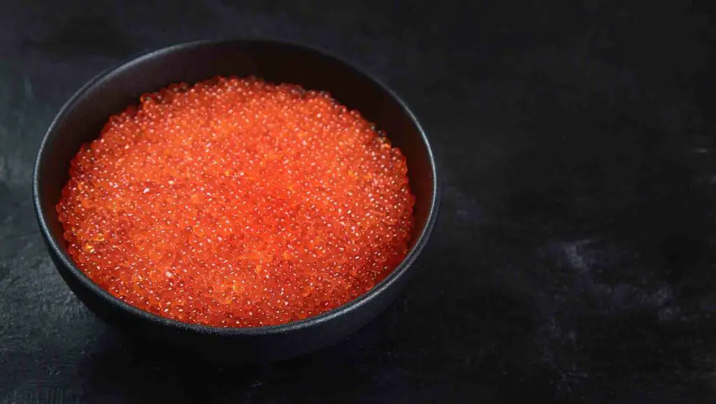 Red caviar in a black bowl