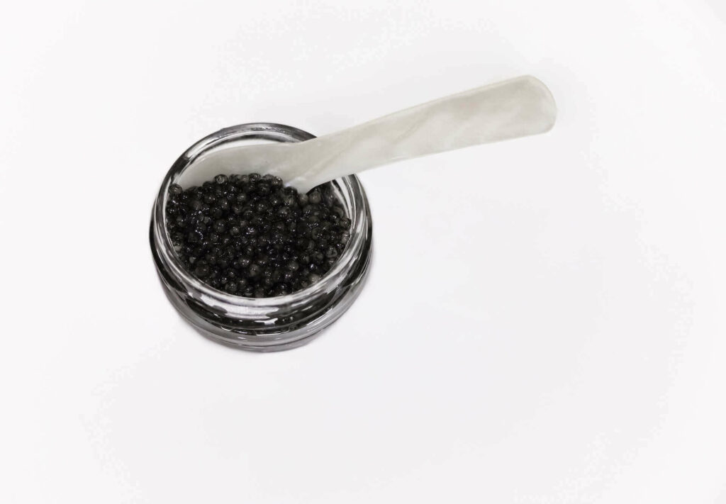 A tin of black caviar with a mother-of-pearl spoon