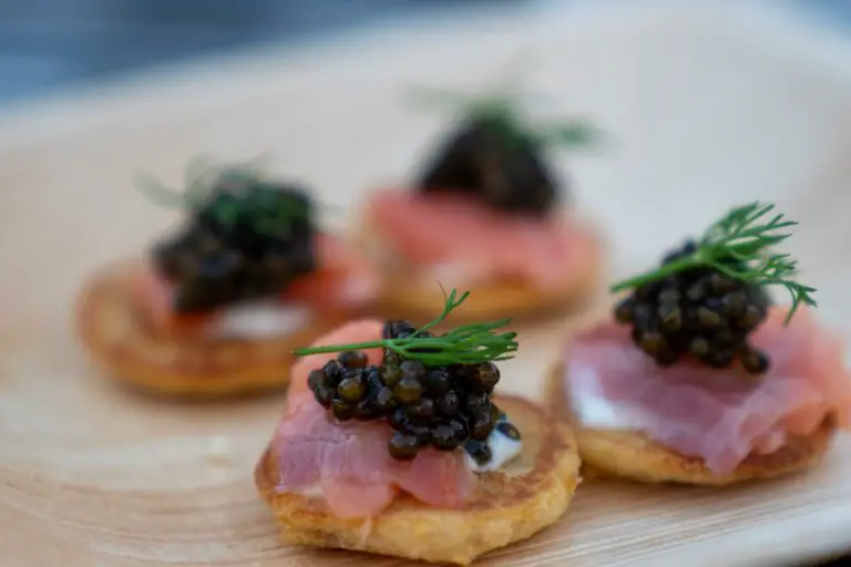 Small pieces of bread and meat with black caviar on top