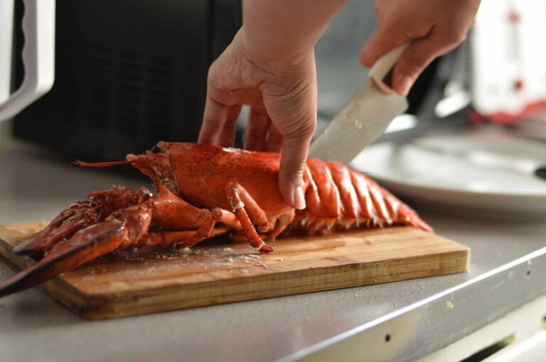 Person cutting the tail of a lobster