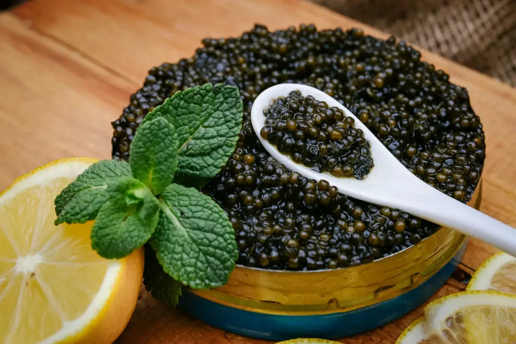 Alt: Black caviar decorated with a leaf