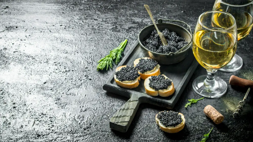 Sandwiches with black caviar on a rustic black background 
