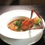 A lobster in a bowl of soup