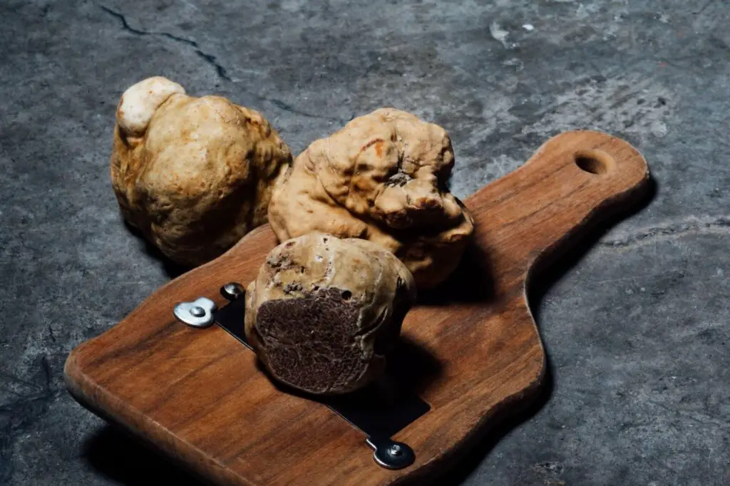 White truffles on a chopping board and stone surface